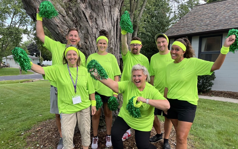 A group of Wisconsin Connections Academy staff posing together in front of a tree