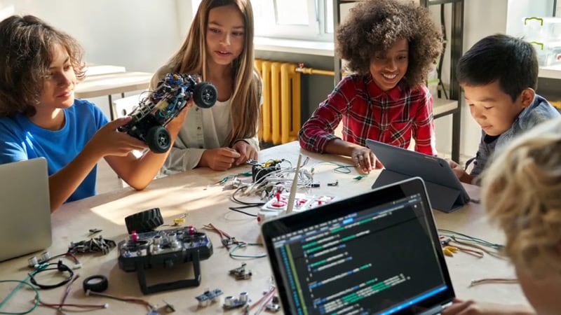 A group of students socializing and engaging in a STEM activity together