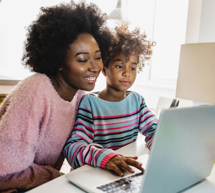 A Learning Coach and online school student looking at a laptop together