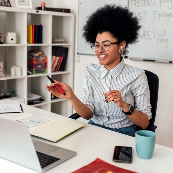 Young adult sitting at an office desk taking an online class