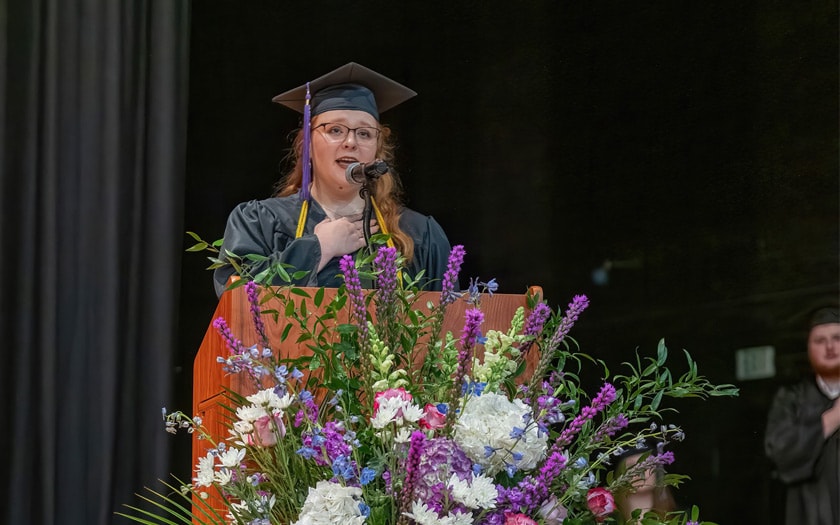 An Alabama Connections Academy student speaking on stage at graduation