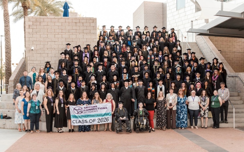 ACA students in their cap and gowns standing on a stairway during the 2026 graduation