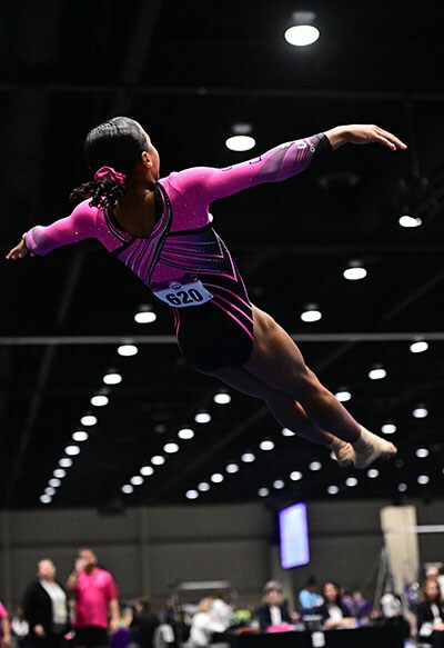 Image of Jaysha McClendon, an Arizona Connections Academy student, performing a double tuck on floor at a gymnastics competition.
