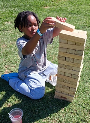 Image of Kelly M from California Connections Academy who is playing a life size version of Jenga out in the sunshine. 