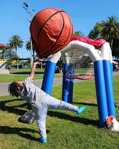 Image of Kelly playing with a giant toy basketball, he is a student at California Connections Academy. 