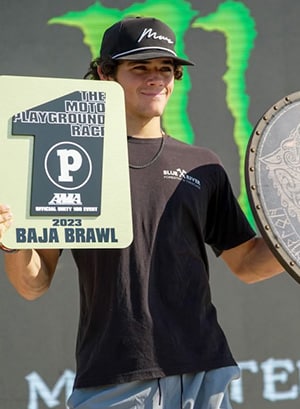 Image of Maddox, a motocross competitor here at a competition showing his 1st place award, he is a student at Colorado Connections Academy. 