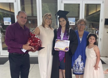 Image of Claudia in her graduation gown along with her family showing her diploma from Georgia Connections Academy. 