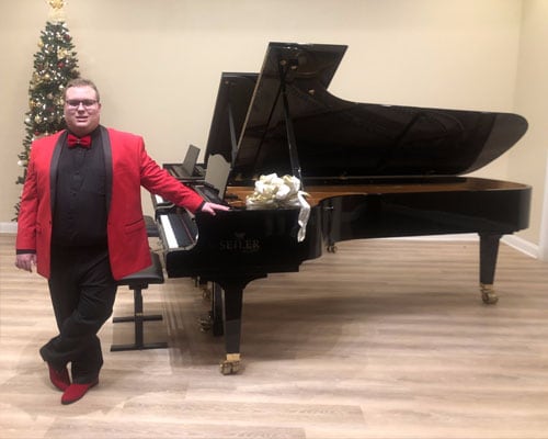 Carson from Georgia Connections Academy standing in front a grand piano. 
