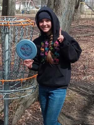 Image of Aryll B holding a disc golf.  She is competing in the world championship of disc golf and is also a student at Michigan Connections Academy. 