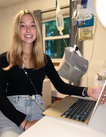 Image of Megan Cichoracki, a graduate of Michigan Connections Academy.  She is wearing a black shirt and is working on her laptop. 