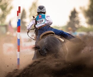 Ava at a rodeo competition riding her horse.