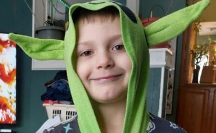 Image of a young boy wearing a green yoda costume.