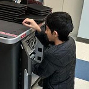 Image of Areeb, he's working on fixing the laptop cart. 