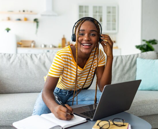 Connections Academy student in a yellow striped shirt smiling while taking an online Math class. 