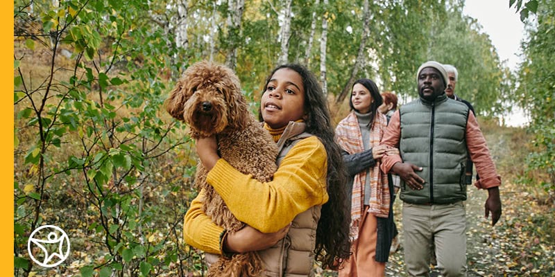A group of students and their family walking through a forest