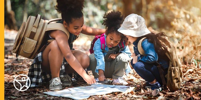 Three students engaging in a world learning activity outside