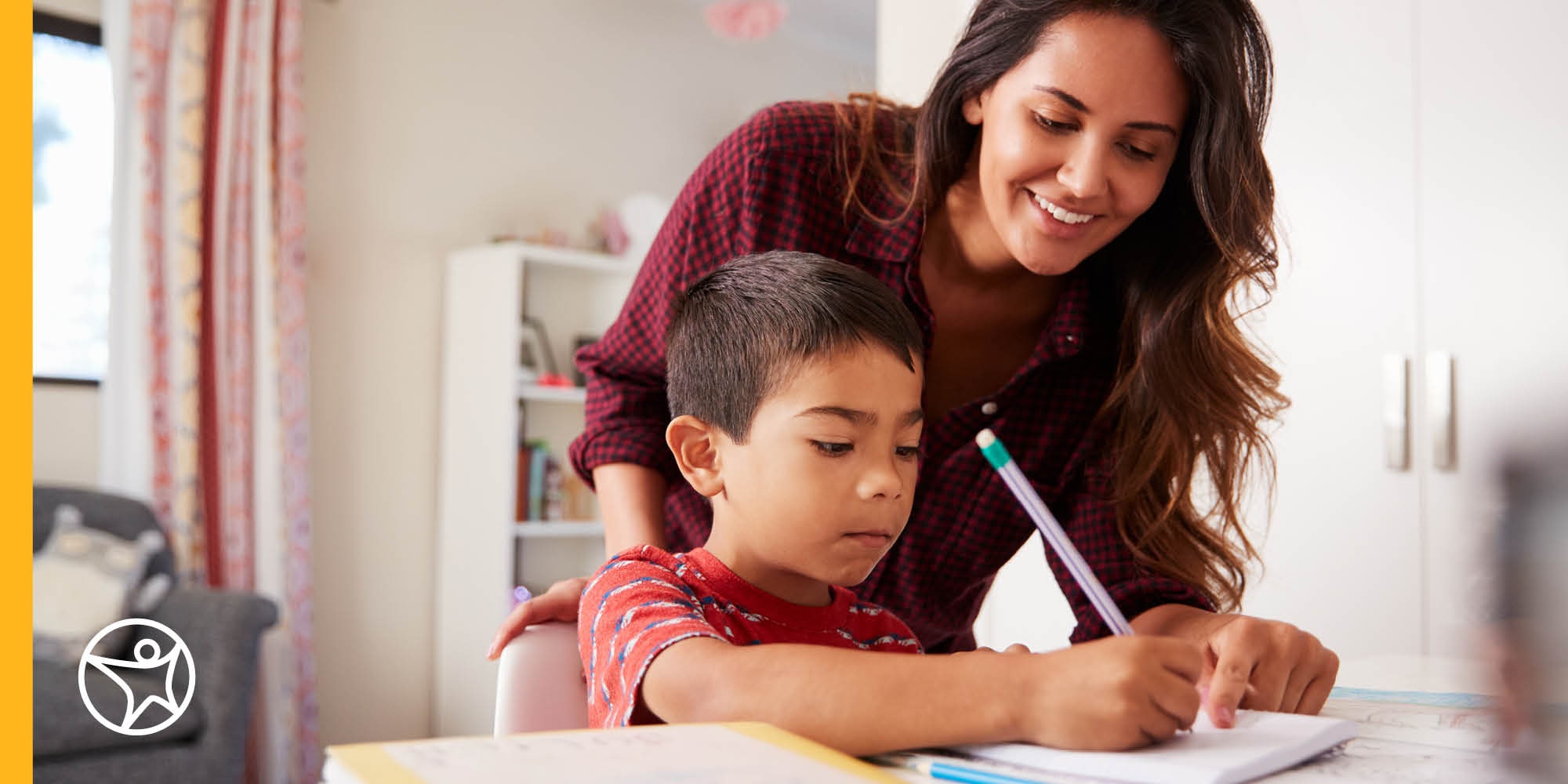 Mother watches over son while he writes in a notebook
