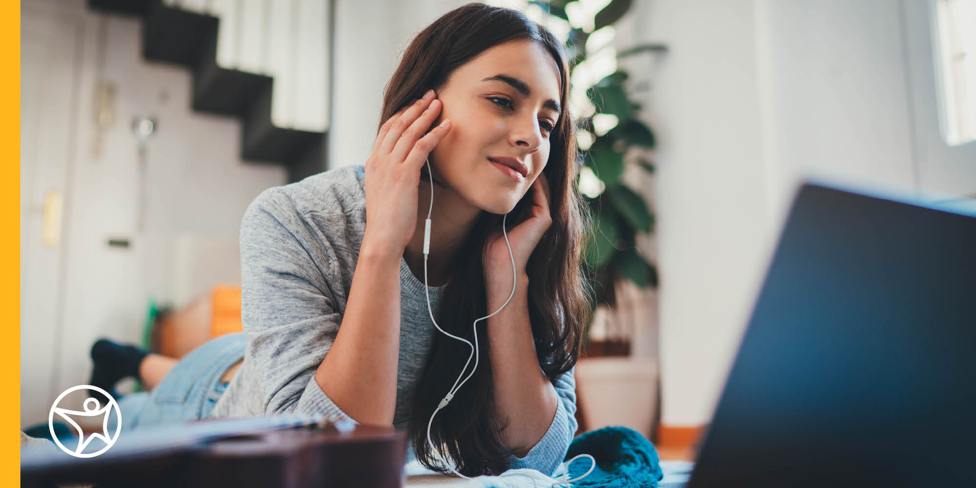 A teenage girl is listening to earphones to listen to online lesson