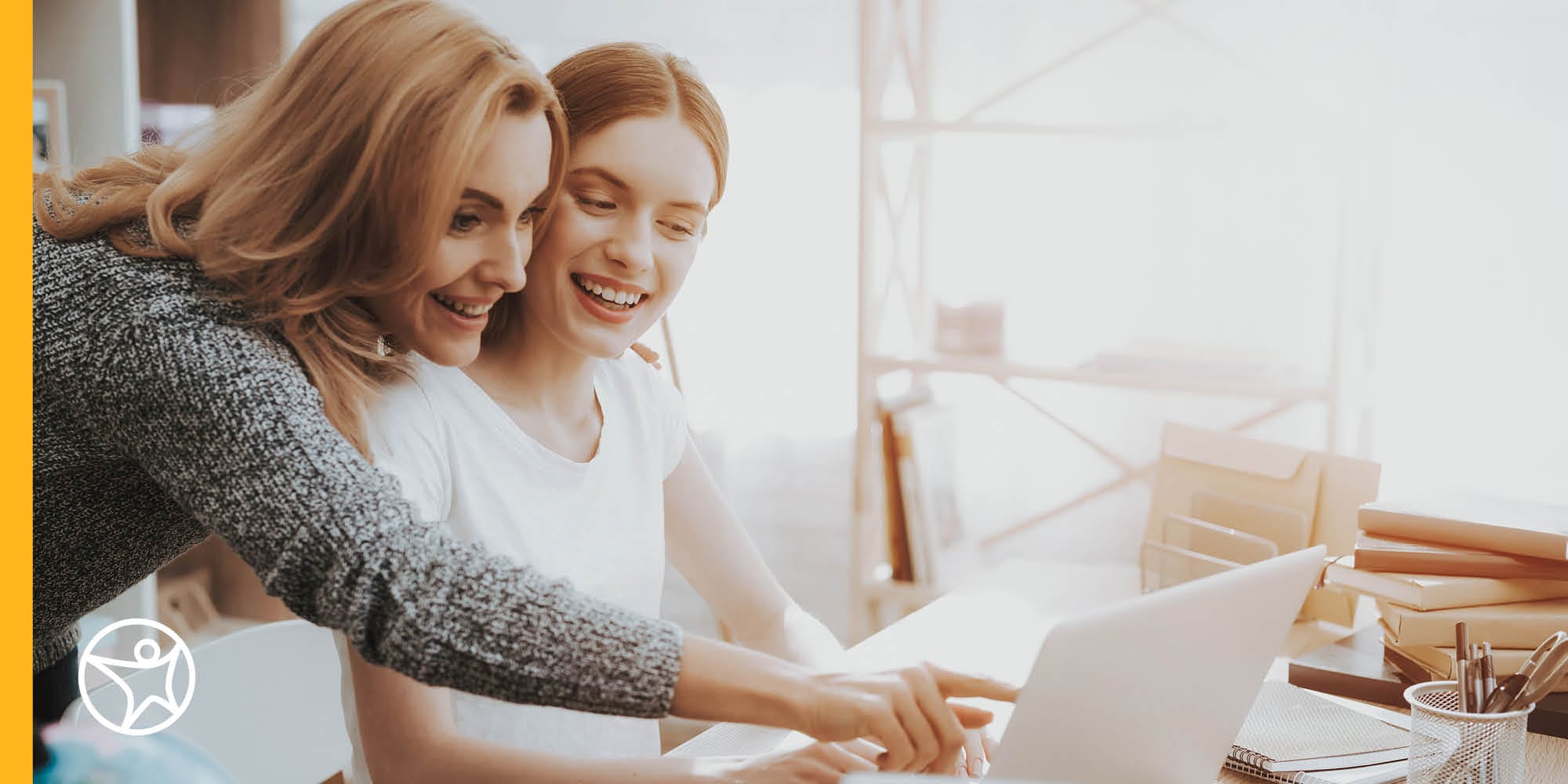 A mother is pointing at a laptop with her daughter