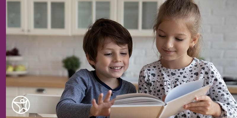 A group of elementary students reading a book together.