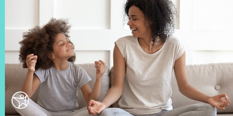 A mother and daughter practicing meditation together