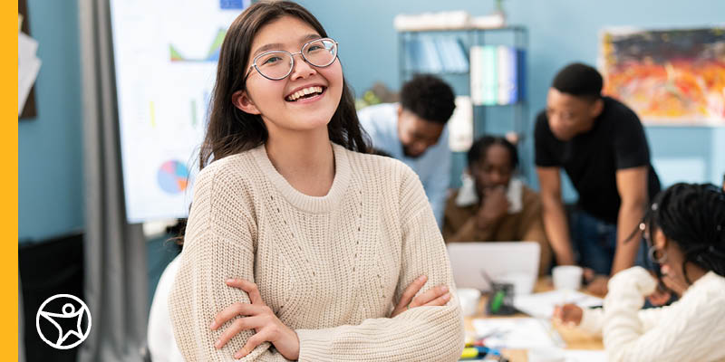 An online school student smiling with her arms crossed