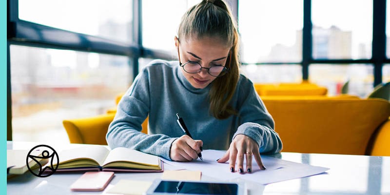 An online school student writing on a piece of paper