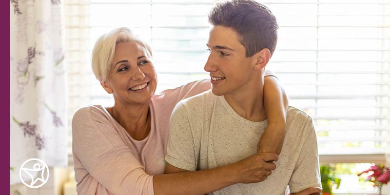 A mother hugging her teenage son - Connections Academy