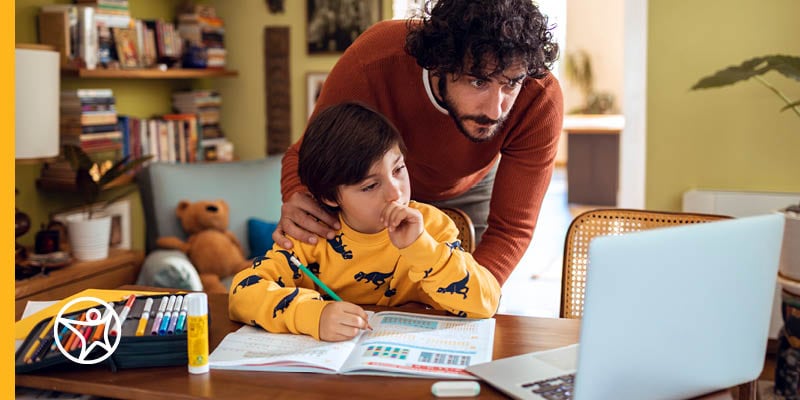 Parent working with child using laptop for online school