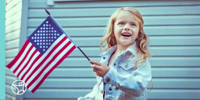 A young girl waving an American flag