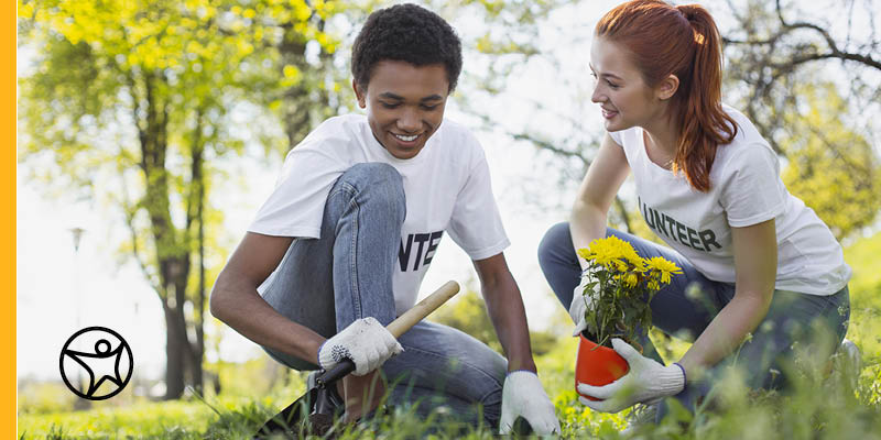 Two teenagers working on a gardening project outside for an Earth Day activity.