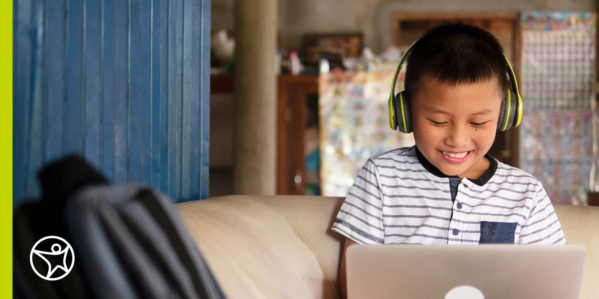 A smiling elementary school student on his laptop