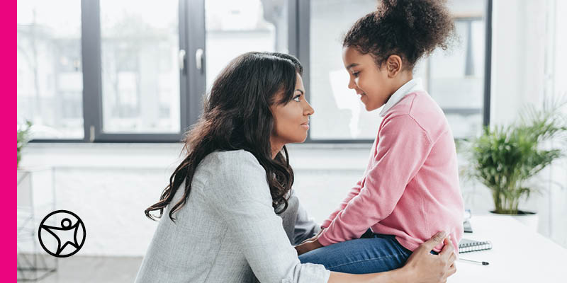 A mother is looking at her daughter who is smiling