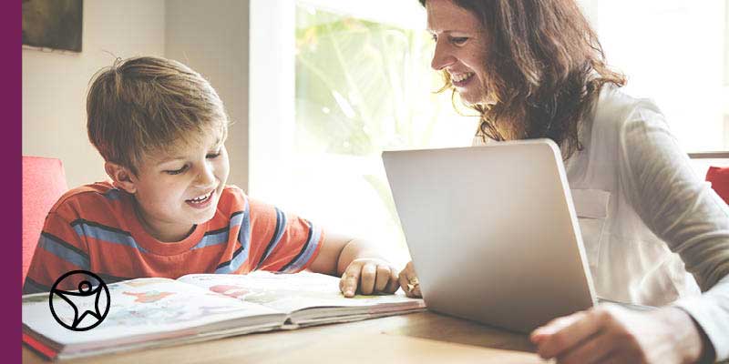 Teacher with laptop helping student with school work