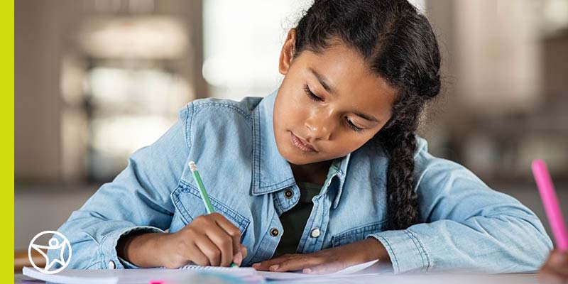 Image of a young female student who working on her vision board for the year for Connecions Academy.