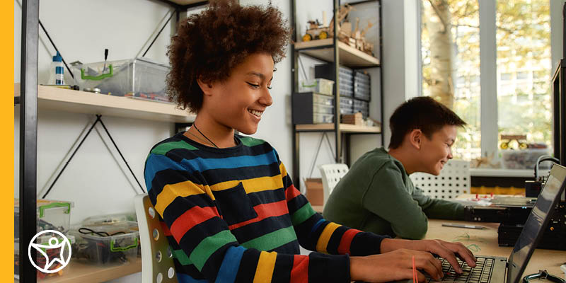 Two students studying at a table together online