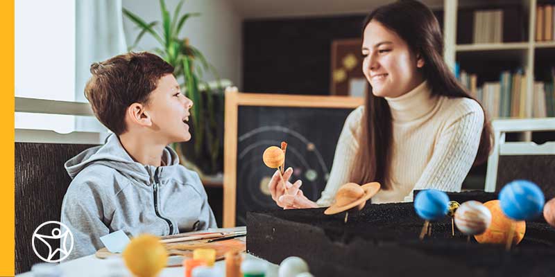 An online school student and parent working on a space activity together