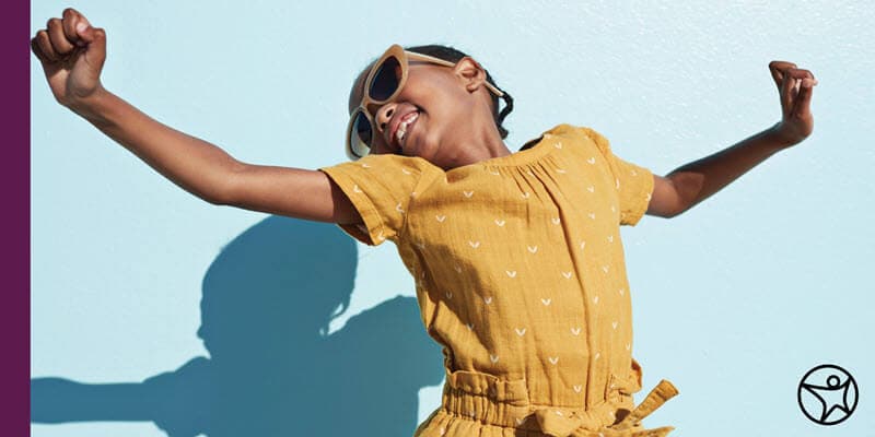 A young girl is dancing with her hands in the air