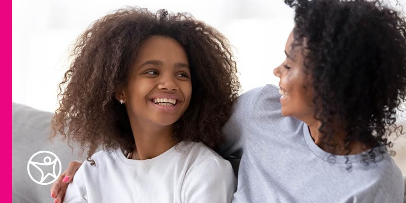 A Learning Coach mother and her daughter smiling at one another.