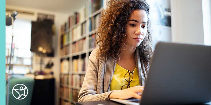 Female student sitting down working at her laptop