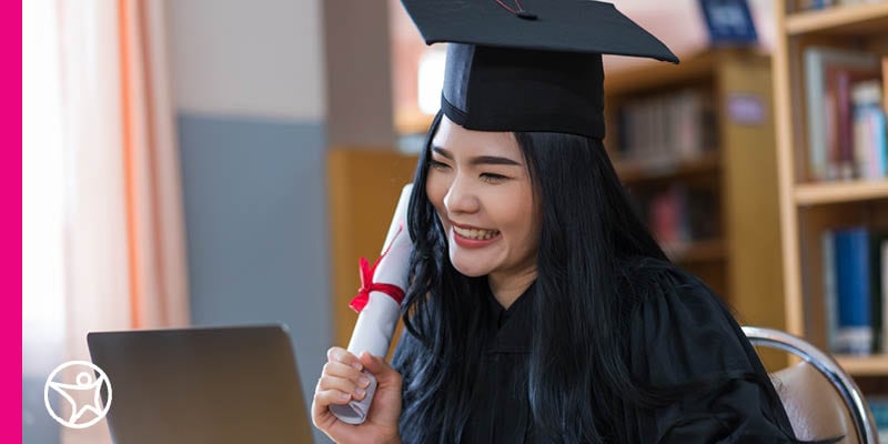 young graduate holding up her diploma during a video call.