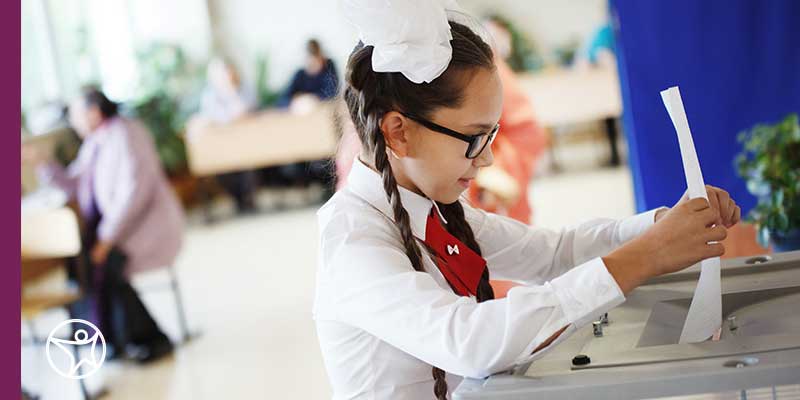 A smiling elementary school student on his laptop