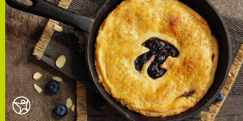 A blueberry pie decorated with a pi symbol in the middle