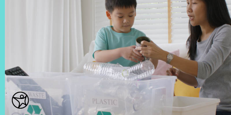 A mother is teacher her son how to recycle properly