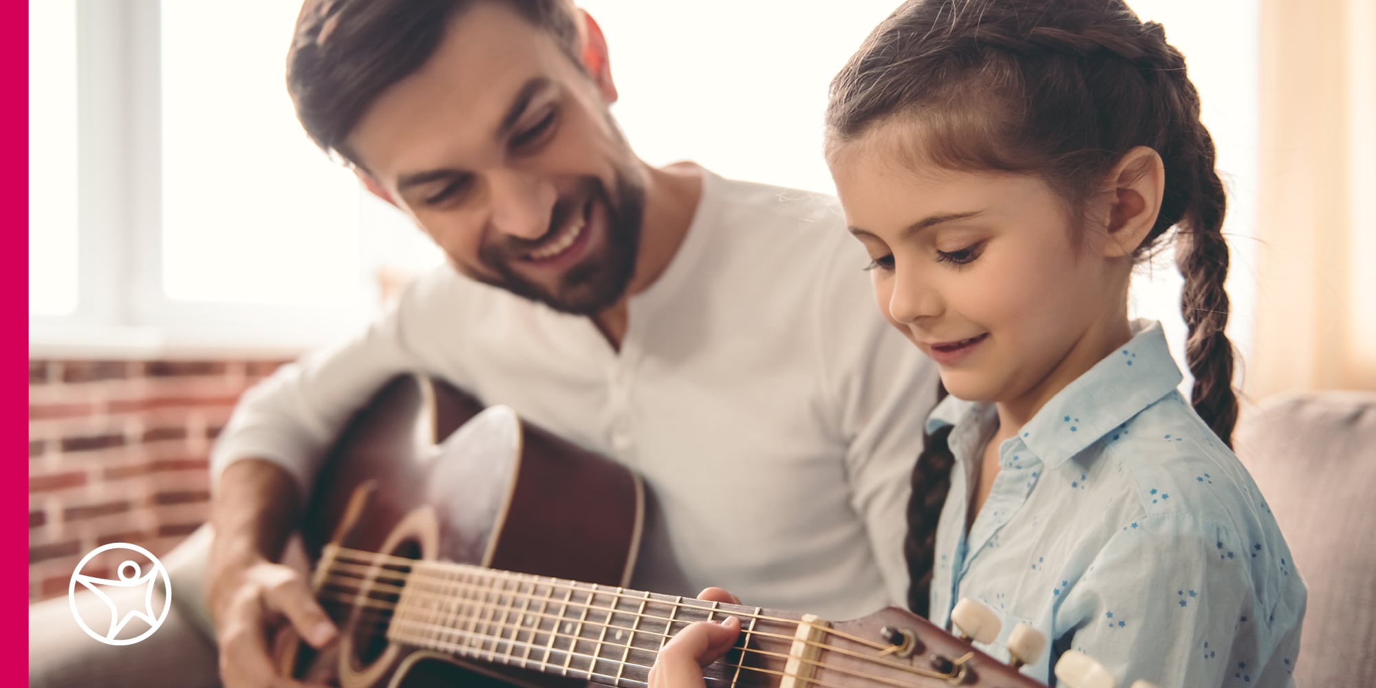 A father is playing guitar with his daughter