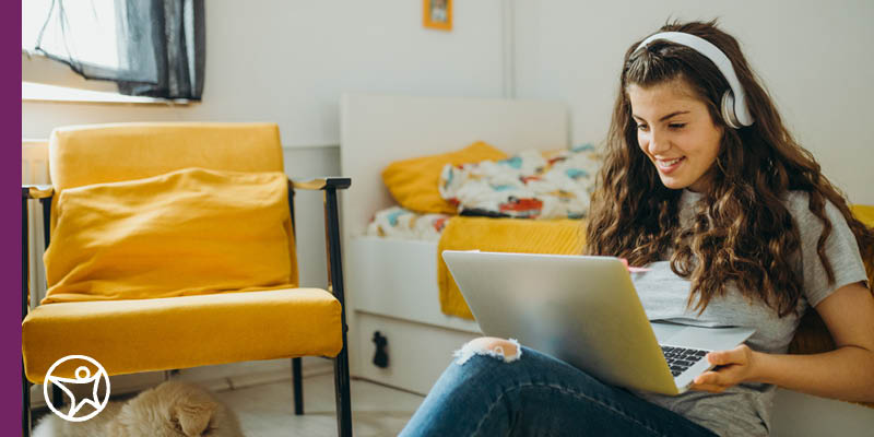 An online school student in their bedroom looking at their laptop