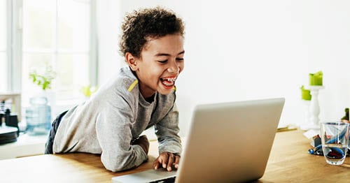 An online school student attending class on his laptop.