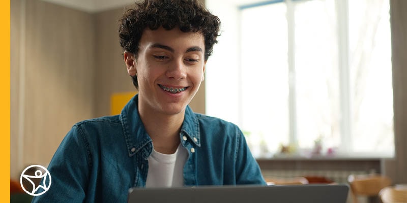 A high school aged student using a laptop