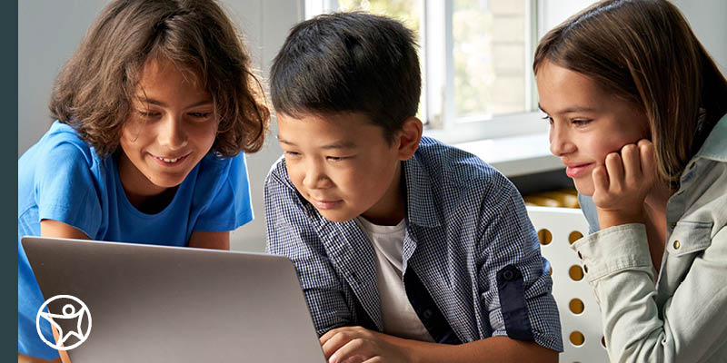 Three students looking at a laptop together