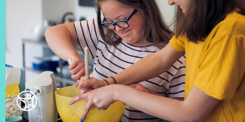 A mother and daughter baking together in a kitchen